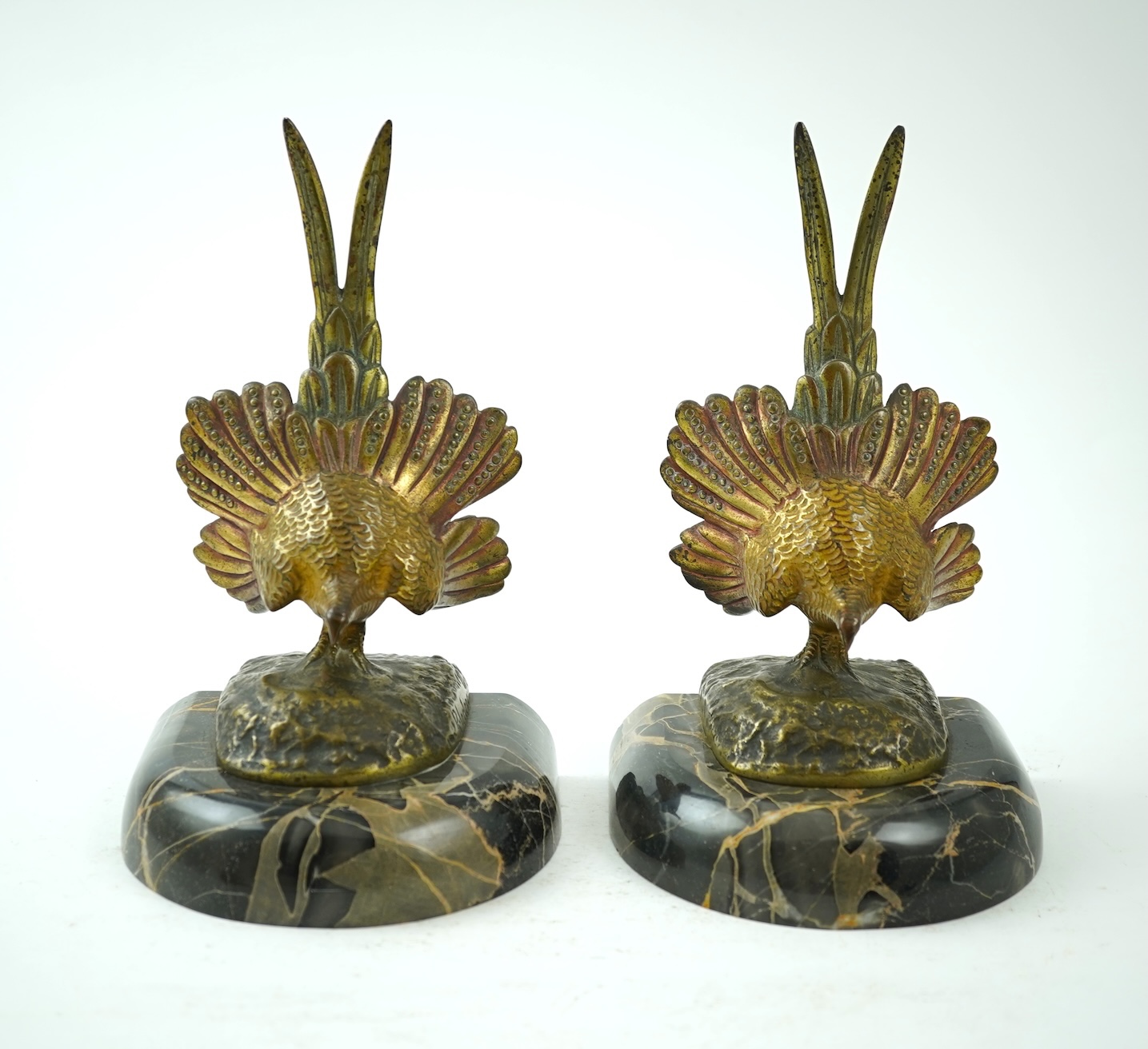 A pair of bronze peacock bookends, with remains of coloured pigments, marble plinths, signed R. Leclerc, 20cm